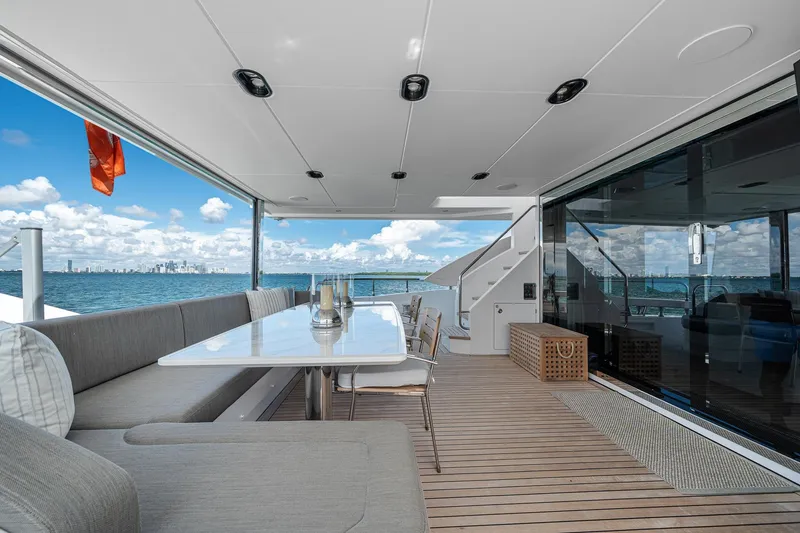 Slide: The Image of Luxurious Azimut Grande 27 METRI yacht deck with ocean view, featuring elegant seating and dining area. - 48
