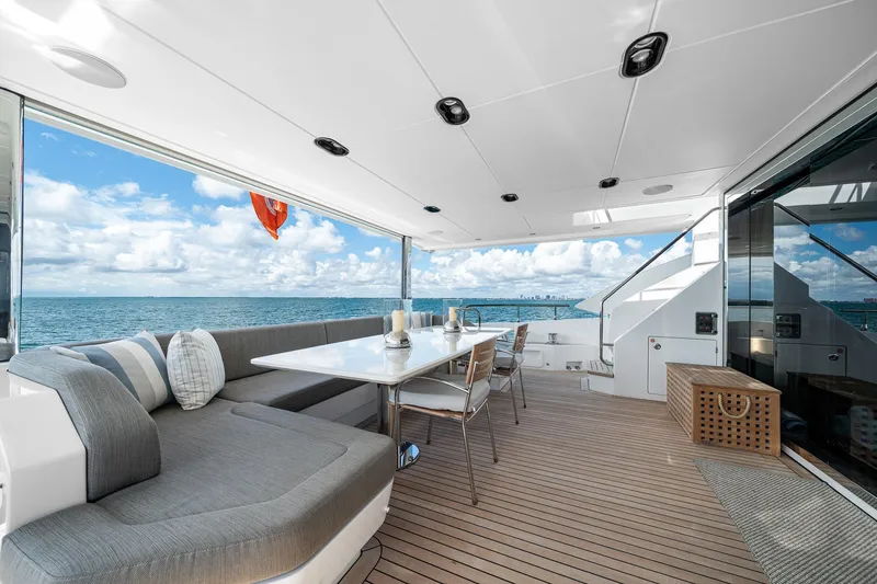 Slide: The Image of Luxurious Azimut Grande 27 METRI yacht deck with ocean view, featuring elegant seating and dining area. - 54