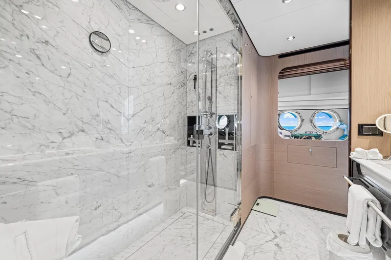 Slide: The Image of Luxurious marble bathroom on 2022 Azimut Grande 27 METRI yacht with glass shower and porthole view. - 97