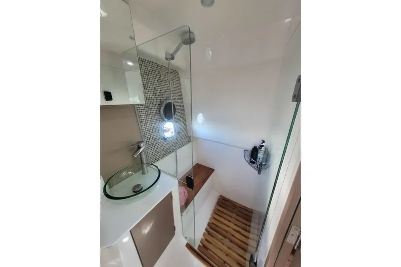 Slide: The Image of Modern bathroom in 2024 Hanover 387 with glass sink, shower, and wooden accents. - 15