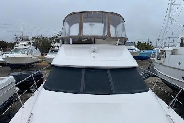 Slide: The Image of 1999 Sea Ray 420 Aft Cabin yacht with enclosed flybridge, docked in a marina. - 10