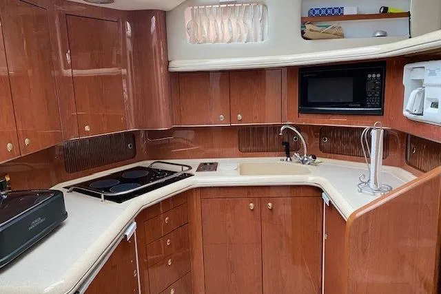 Slide: The Image of Luxurious kitchen in 1999 Sea Ray 420 Aft Cabin yacht with wood cabinetry and modern appliances. - 12