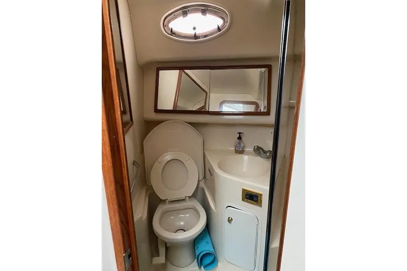 Slide: The Image of 1999 Sea Ray 420 Aft Cabin bathroom with toilet, sink, and mirror. - 15