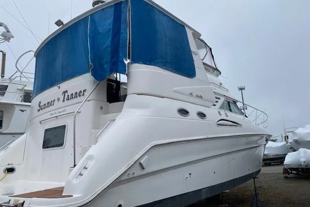 Slide: The Image of 1999 Sea Ray 420 Aft Cabin yacht with blue canopy, docked on land. - 8
