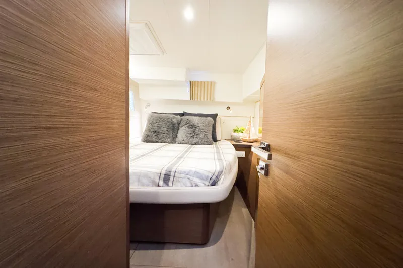Slide: The Image of Cozy bedroom interior of 2018 Lagoon 40 catamaran with plush bedding and wooden accents. - 45