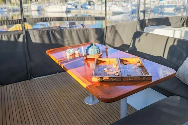 Slide: The Image of Luxurious Lagoon 40 catamaran interior with wooden table, backgammon set, and decorative items, 2018 model. - 60