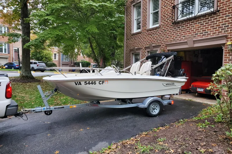 Slide: The Image of 2020 Boston Whaler 130 Super Sport boat on trailer in residential driveway. - 3