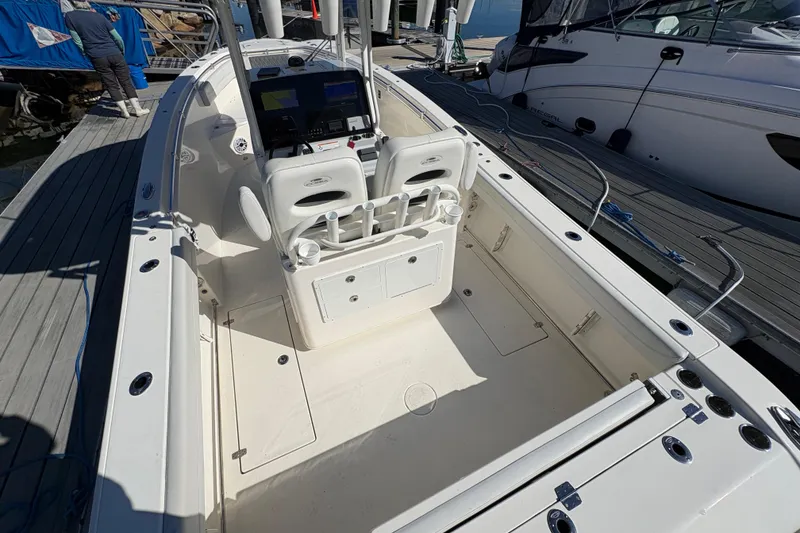 Slide: The Image of 2022 Cobia 280 Center Console boat docked, showcasing spacious deck and seating area. - 10