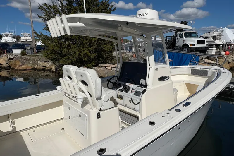 Slide: The Image of 2022 Cobia 280 Center Console boat docked, featuring dual seats and advanced navigation equipment. - 13