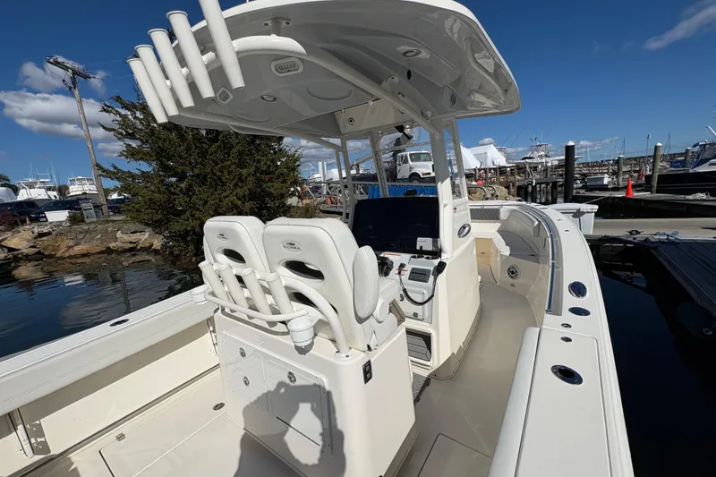 Slide: The Image of 2022 Cobia 280 Center Console boat docked, featuring spacious seating and modern controls. - 14