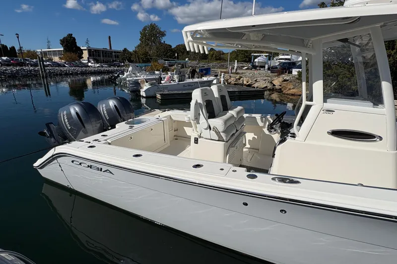 Slide: The Image of 2022 Cobia 280 Center Console boat docked with twin Yamaha engines. - 15