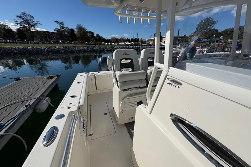 Slide: The Image of 2022 Cobia 280 Center Console boat docked at marina, showcasing seating and console. - 16