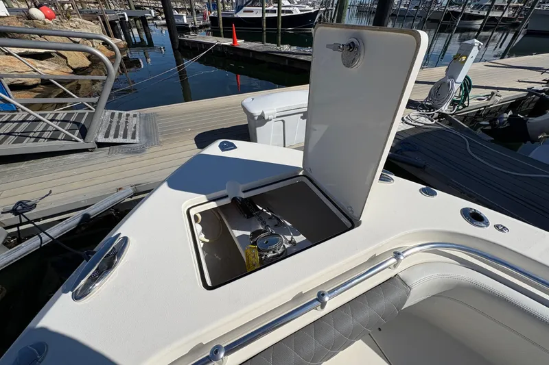 Slide: The Image of 2022 Cobia 280 Center Console boat with open storage compartment at marina dock. - 21