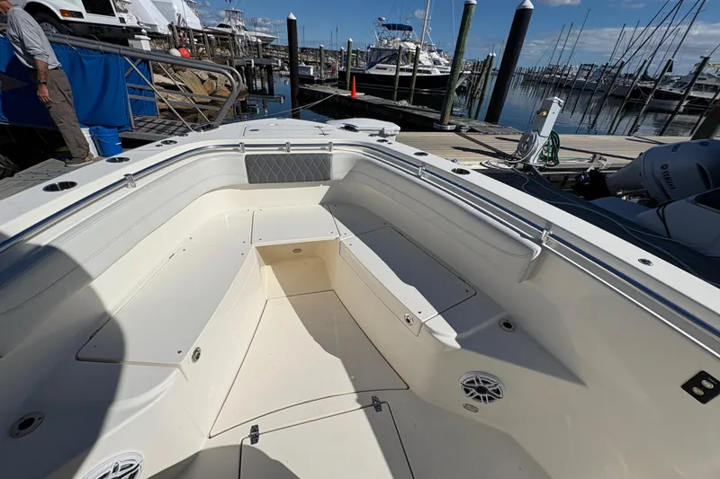 Slide: The Image of 2022 Cobia 280 Center Console boat interior at marina, featuring spacious seating and storage. - 23