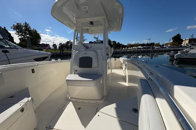 Slide: The Image of 2022 Cobia 280 Center Console boat docked in a marina under clear blue skies. - 24