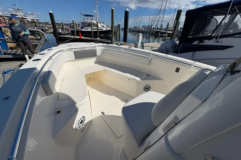 Slide: The Image of 2022 Cobia 280 Center Console boat docked at marina under clear blue sky. - 25