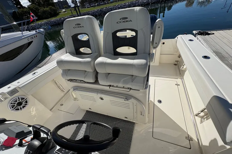 Slide: The Image of 2022 Cobia 280 Center Console boat interior with dual seats and steering wheel. - 28