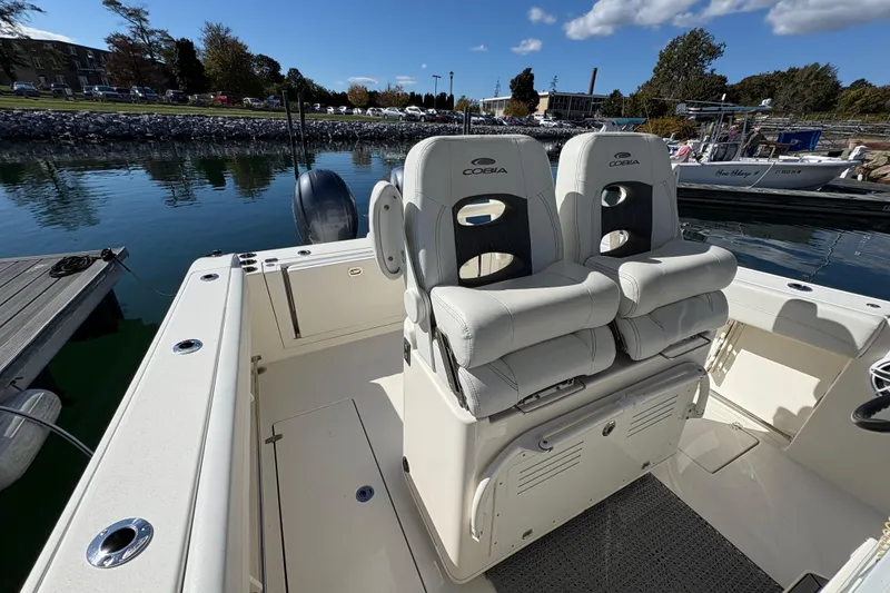 Slide: The Image of 2022 Cobia 280 Center Console boat interior with dual seats at dock. - 31