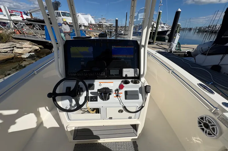 Slide: The Image of 2022 Cobia 280 Center Console boat dashboard with steering wheel and navigation equipment. - 33