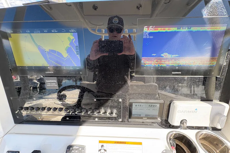 Slide: The Image of Cobia 280 Center Console 2022 dashboard with Garmin navigation displays and controls. - 35