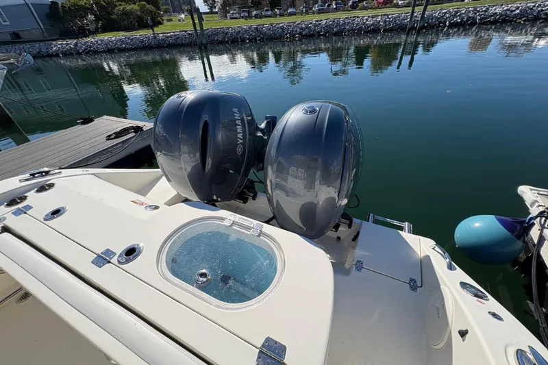 Slide: The Image of 2022 Cobia 280 Center Console with dual Yamaha outboard engines docked by the water. - 39