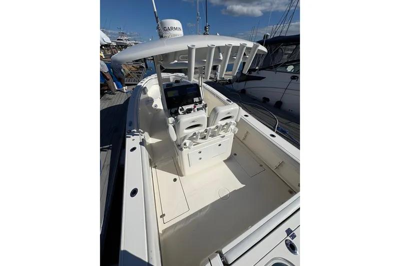 Slide: The Image of 2022 Cobia 280 Center Console boat with Garmin equipment, docked under a clear sky. - 42