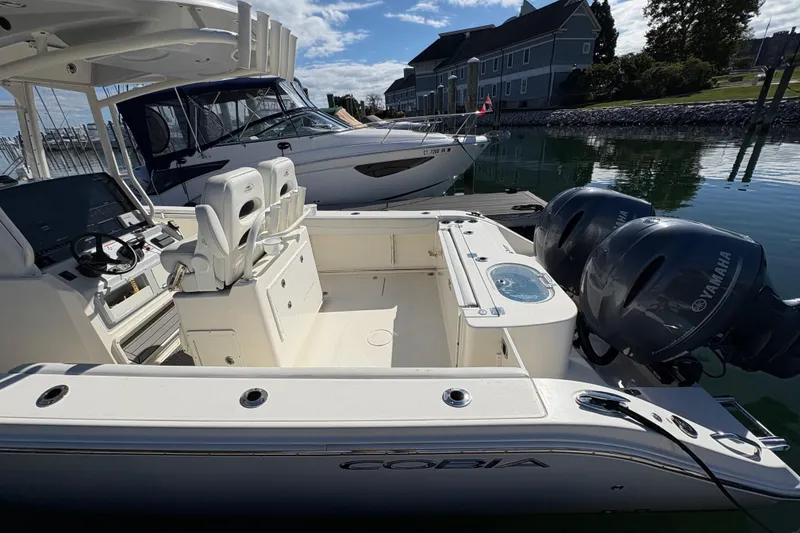 Slide: The Image of 2022 Cobia 280 Center Console boat with Yamaha engines docked in marina. - 43