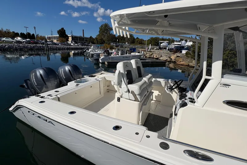Slide: The Image of 2022 Cobia 280 Center Console boat with dual Yamaha engines docked in a marina. - 46