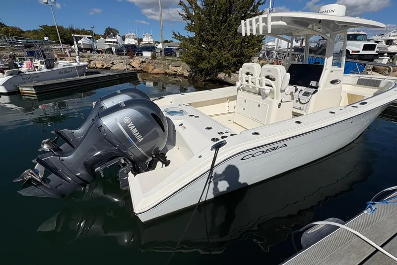 Slide: The Image of 2022 Cobia 280 Center Console boat with Yamaha engines docked at marina. - 49