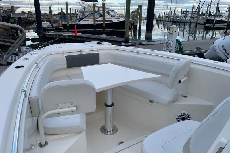 Slide: The Image of 2022 Cobia 280 Center Console boat with seating and table at marina. - 53