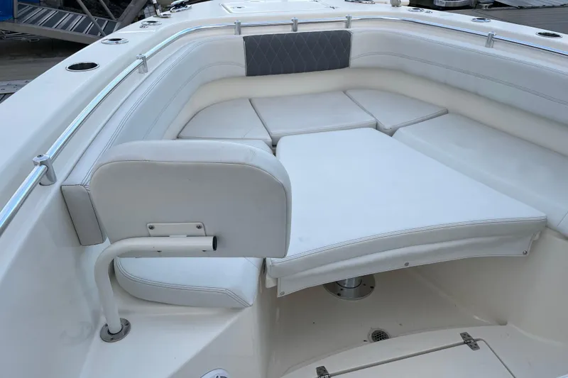 Slide: The Image of 2022 Cobia 280 Center Console boat interior with cushioned seating and stainless steel railings. - 54