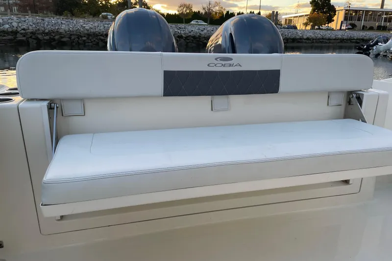 Slide: The Image of 2022 Cobia 280 Center Console boat with cushioned seating and dual engines. - 57