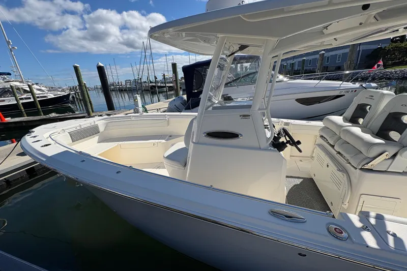Slide: The Image of 2022 Cobia 280 Center Console boat docked at marina under blue sky. - 6