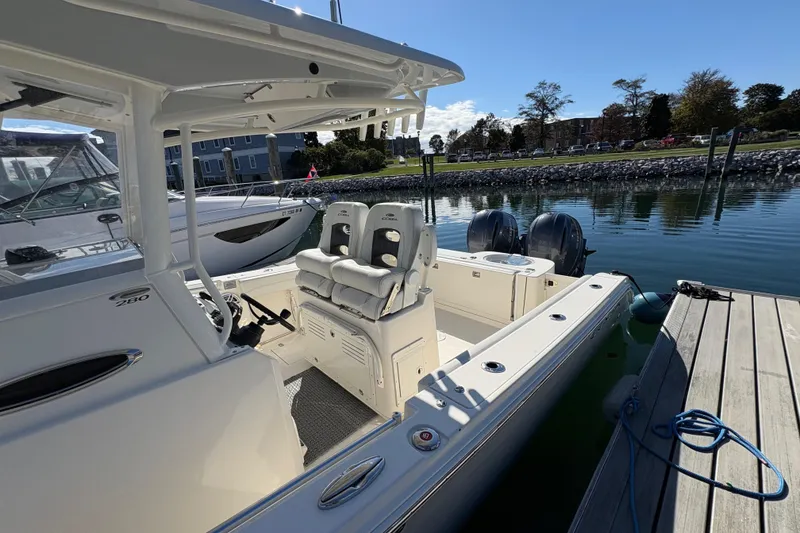 Slide: The Image of 2022 Cobia 280 Center Console boat docked, featuring dual engines and spacious seating. - 7
