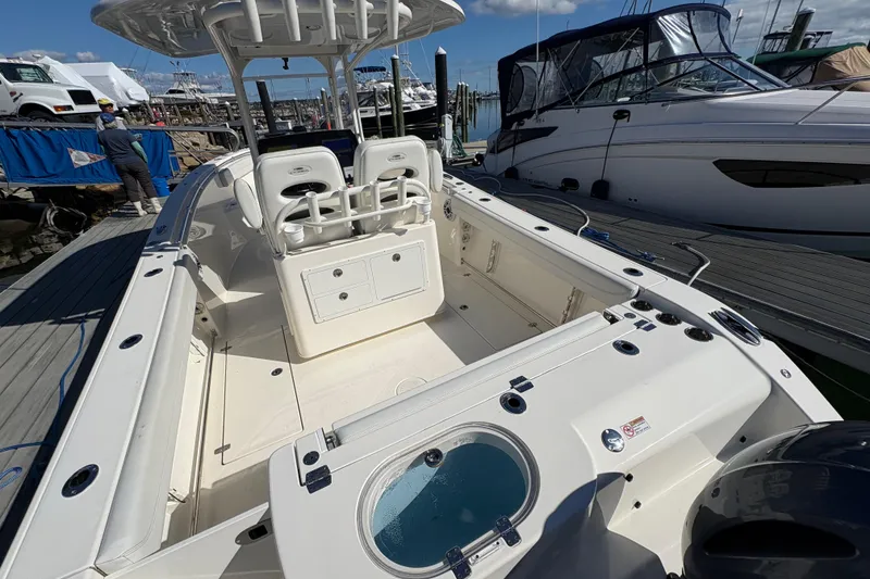 Slide: The Image of 2022 Cobia 280 Center Console boat docked, showcasing spacious deck and seating area. - 9