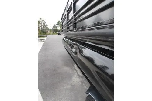 Slide: The Image of 2021 Regency 250 LE3 Sport boat, sleek black exterior, parked on a paved surface. - 10