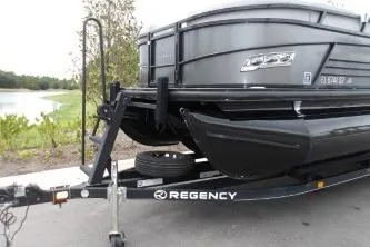Slide: The Image of 2021 Regency 250 LE3 Sport boat on trailer near a lake. - 5