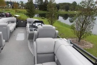 Slide: The Image of 2021 Regency 250 LE3 Sport pontoon boat interior by a scenic lake. - 8