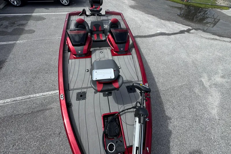 Slide: The Image of 2022 Vexus AVX1880 boat with red and gray interior, parked on asphalt. - 13