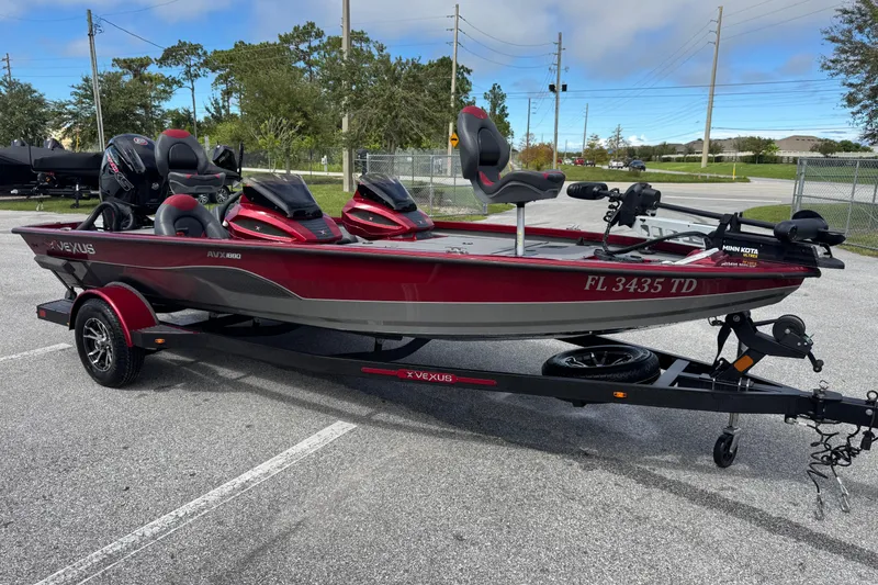 Slide: The Image of 2022 Vexus AVX1880 boat on trailer, red and gray, parked outdoors. - 3