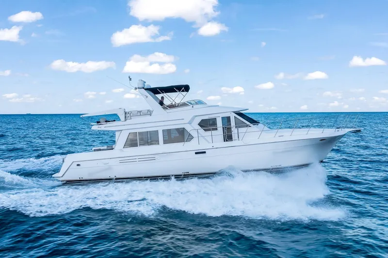 Slide: The Image of 2003 Navigator Rival 5700 yacht cruising on open blue sea under clear sky. - 1