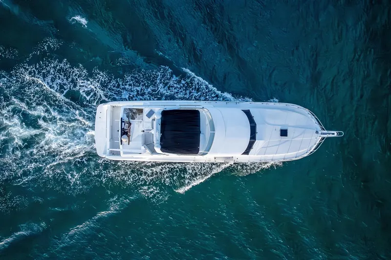 Slide: The Image of Aerial view of 2003 Navigator Rival 5700 yacht cruising on blue ocean waters. - 11