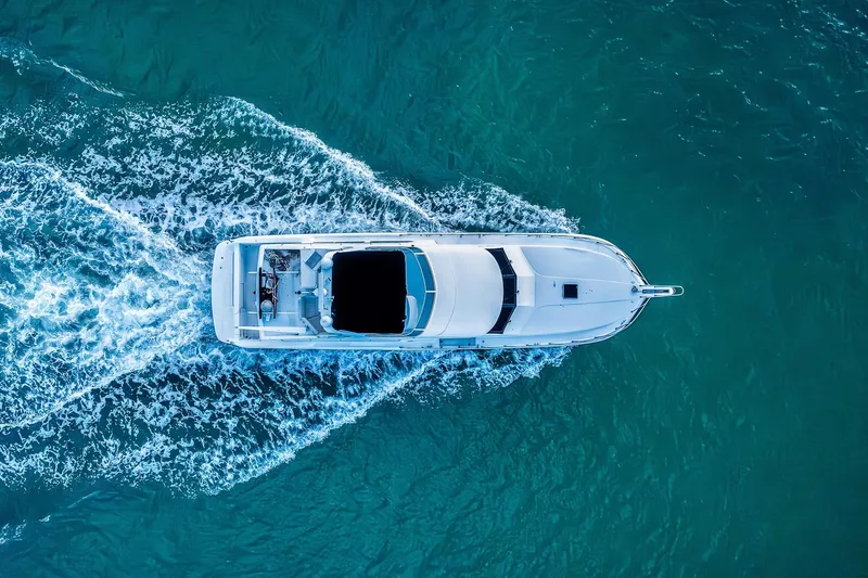 Slide: The Image of Aerial view of 2003 Navigator Rival 5700 yacht cruising in turquoise waters. - 12
