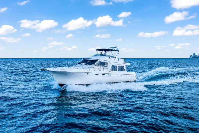 Slide: The Image of 2003 Navigator Rival 5700 yacht cruising on open blue sea under clear sky. - 13