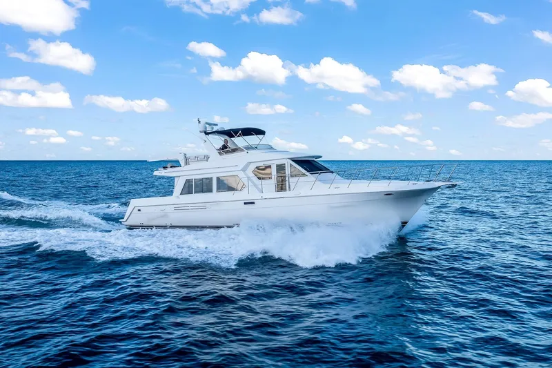 Slide: The Image of 2003 Navigator Rival 5700 yacht cruising on open sea under blue sky. - 14