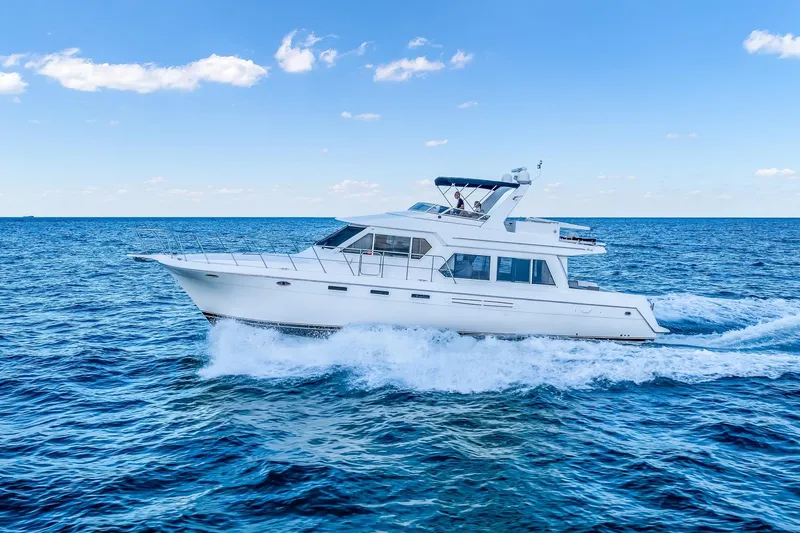 Slide: The Image of 2003 Navigator Rival 5700 yacht cruising on open blue sea under clear sky. - 15