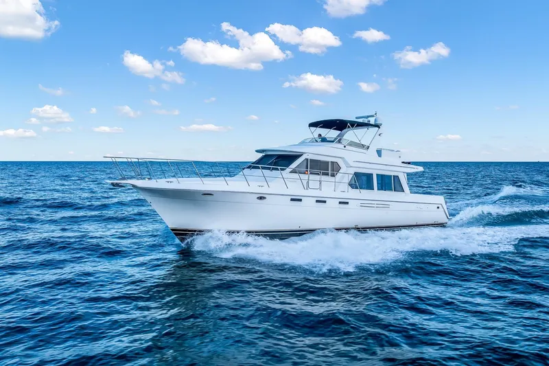 Slide: The Image of 2003 Navigator Rival 5700 yacht cruising on open sea under blue sky. - 2