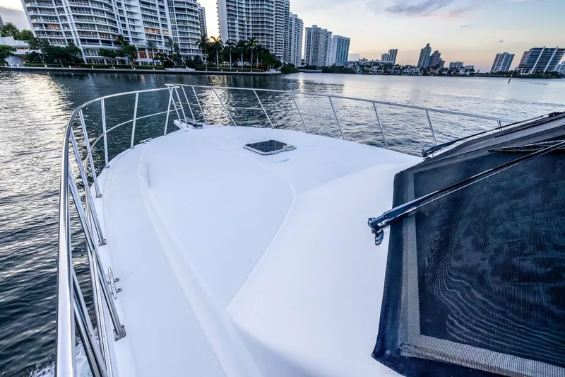 Slide: The Image of 2003 Navigator Rival 5700 yacht cruising near city skyline at sunset. - 21