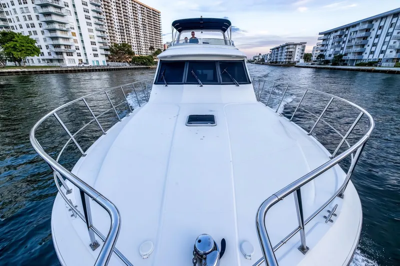 Slide: The Image of 2003 Navigator Rival 5700 yacht cruising through a city canal, surrounded by buildings. - 22