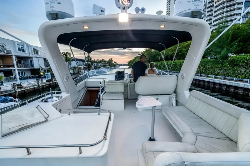 Slide: The Image of 2003 Navigator Rival 5700 yacht interior with seating, cruising along a scenic canal at sunset. - 23